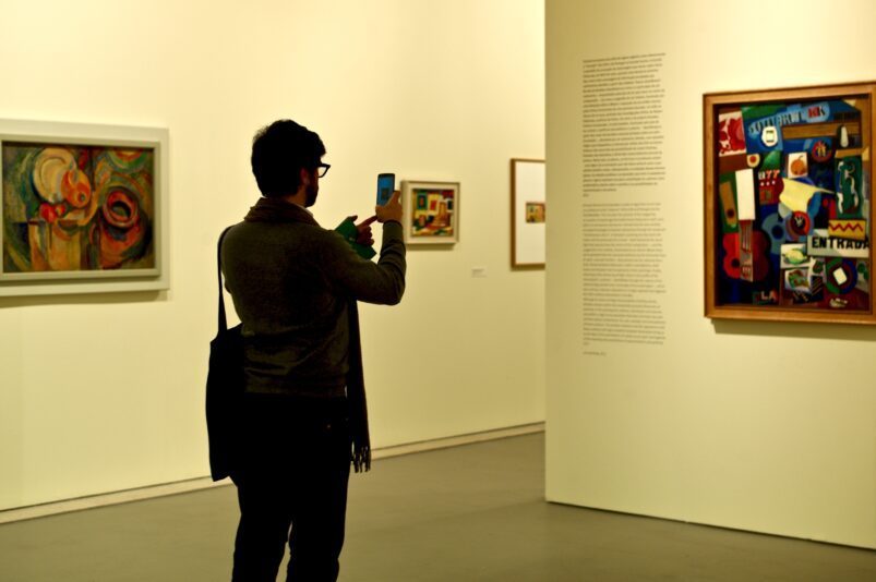 Man die een foto neemt van een schilderij in een museum