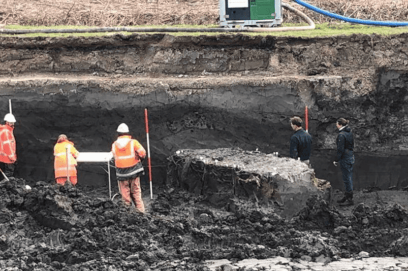 Archäologen entdecken eine Struktur aus Ton und Holzstangen; eine Art Deich, Deich oder Damm